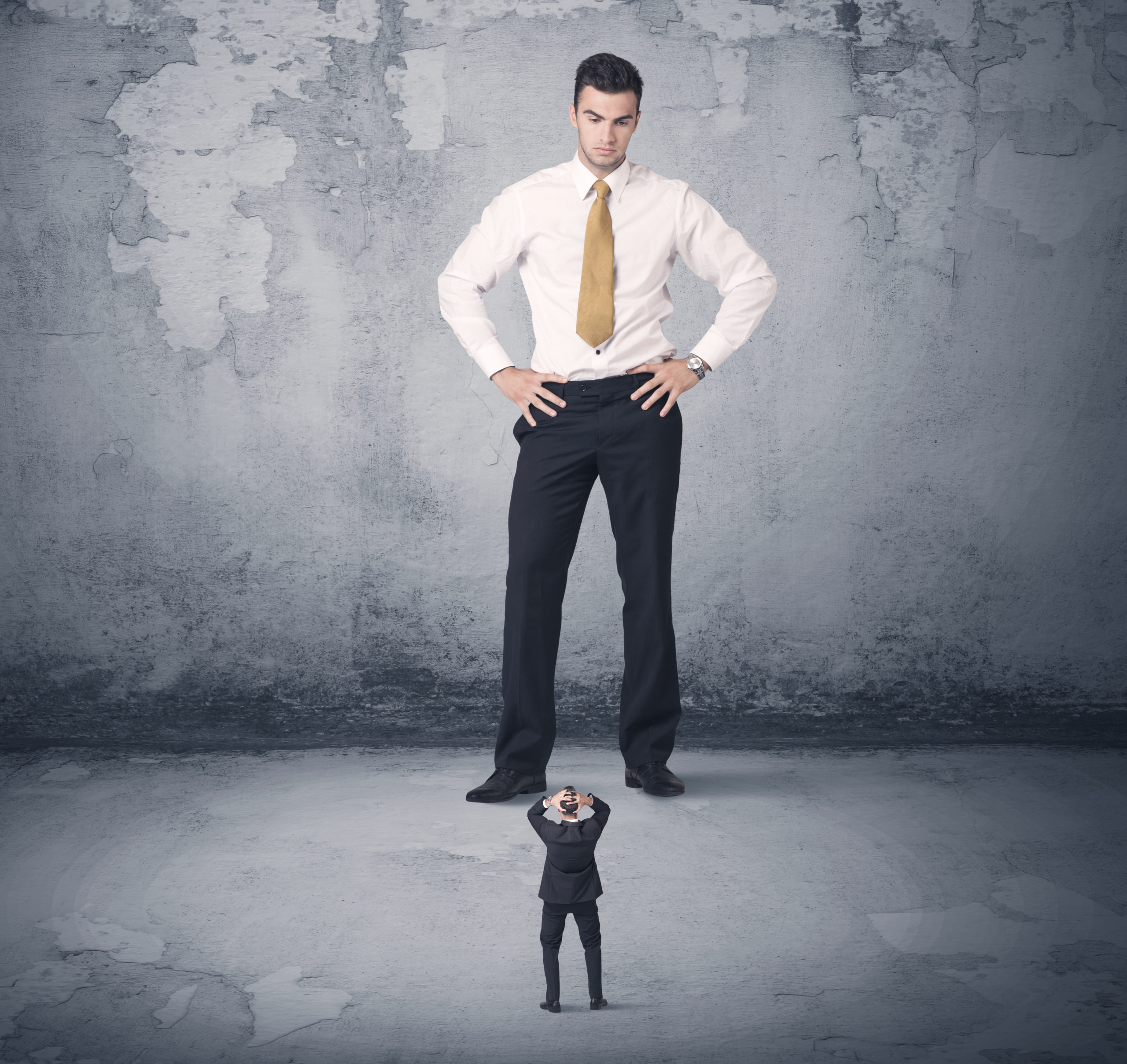 Big angry business bully looking at small coworker concept on background